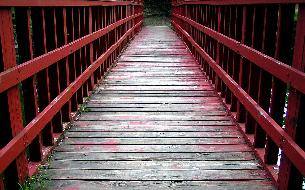 Rode parkbank op houten hek