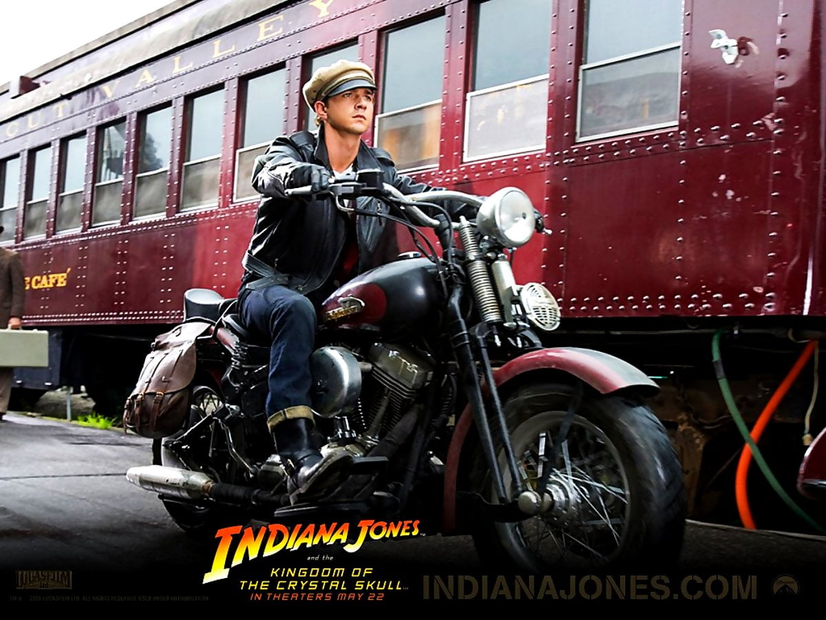 Gratis afbeelding voor achtergrond HD — man rijden motorfiets voor gebouw (scène uit film "Indiana Jones")